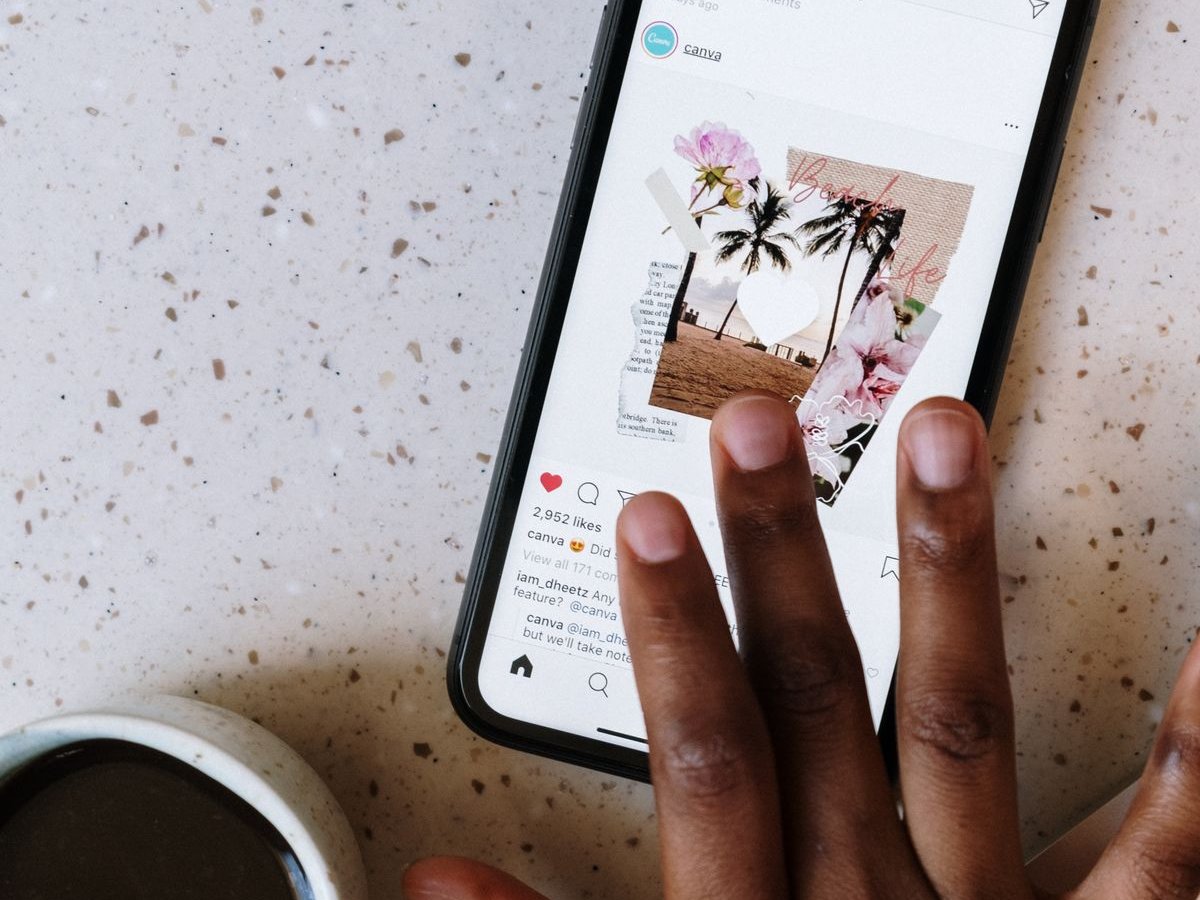 Hand scrolling a social media feed on a smartphone
